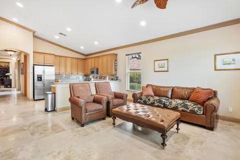 a kitchen with stainless steel appliances granite countertop a sink a stove a refrigerator cabinets and a window