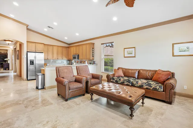 a kitchen with stainless steel appliances granite countertop a sink a stove a refrigerator cabinets and a window