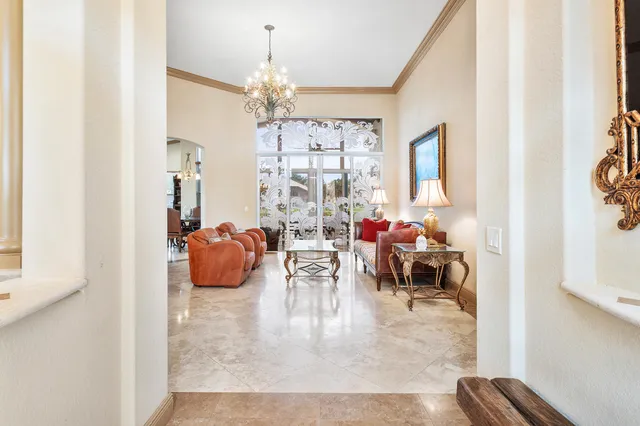 a view of a dining room with furniture a chandelier and a window