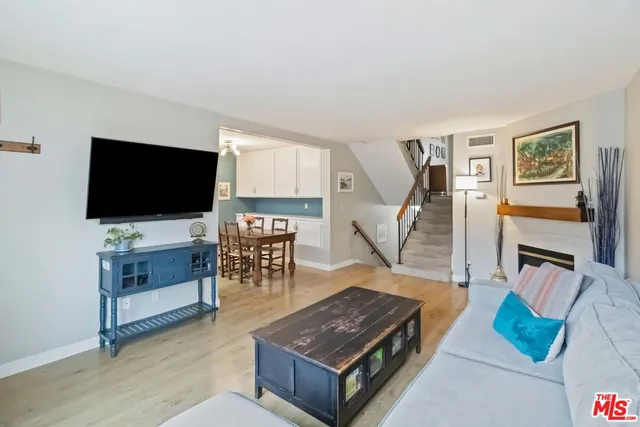 a view of an empty room with wooden floor and a fireplace