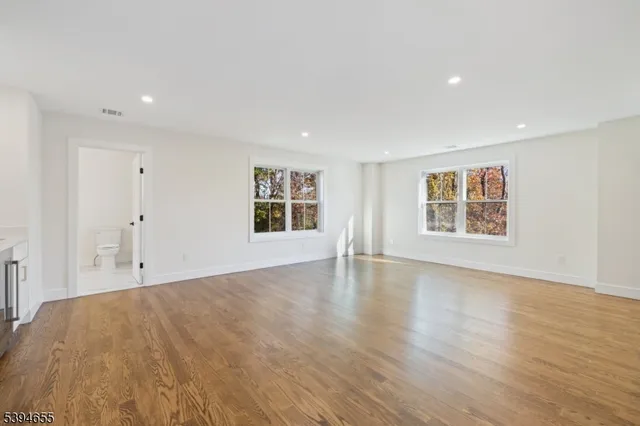 a view of a big room with wooden floor and windows