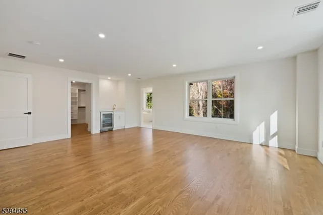 a view of an empty room with wooden floor