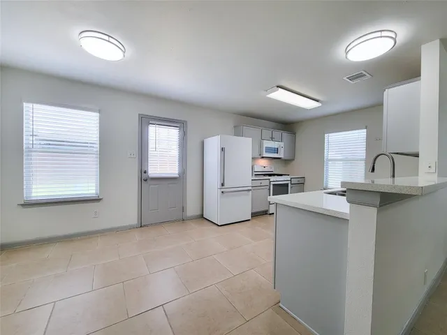 a kitchen with white cabinets and white appliances