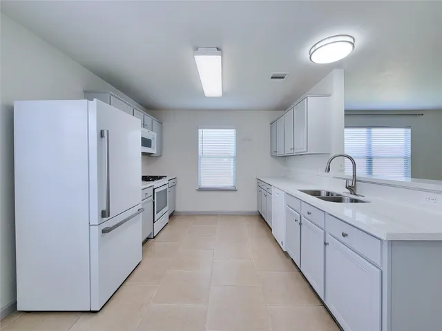 a kitchen with granite countertop a refrigerator and a sink