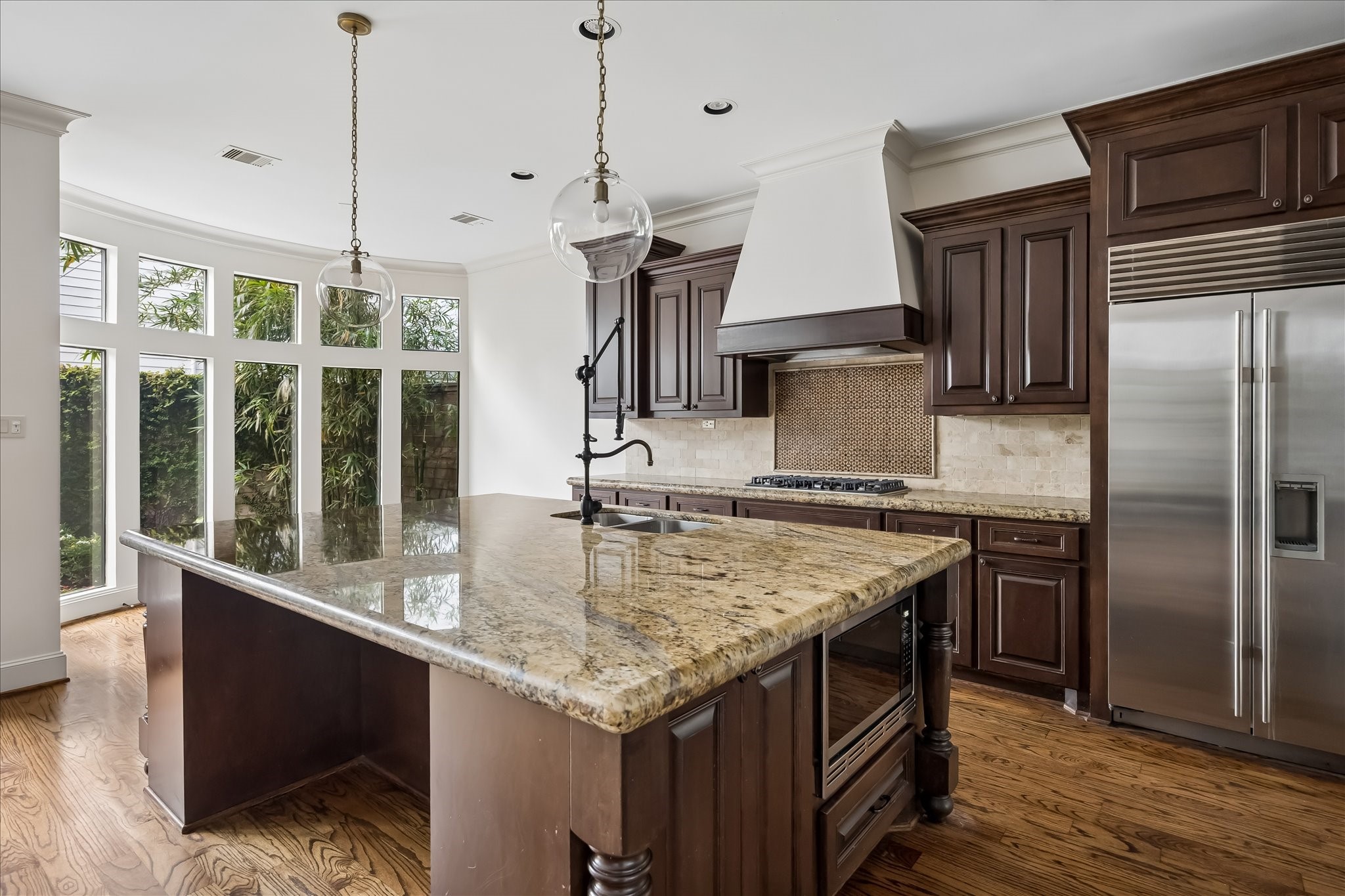 2246 Branard Street Houston, TX 77098 - Photo 14 of 40 Well-appointed kitchen with expansive island, stainless steel appliances, and views of the surrounding greenery.