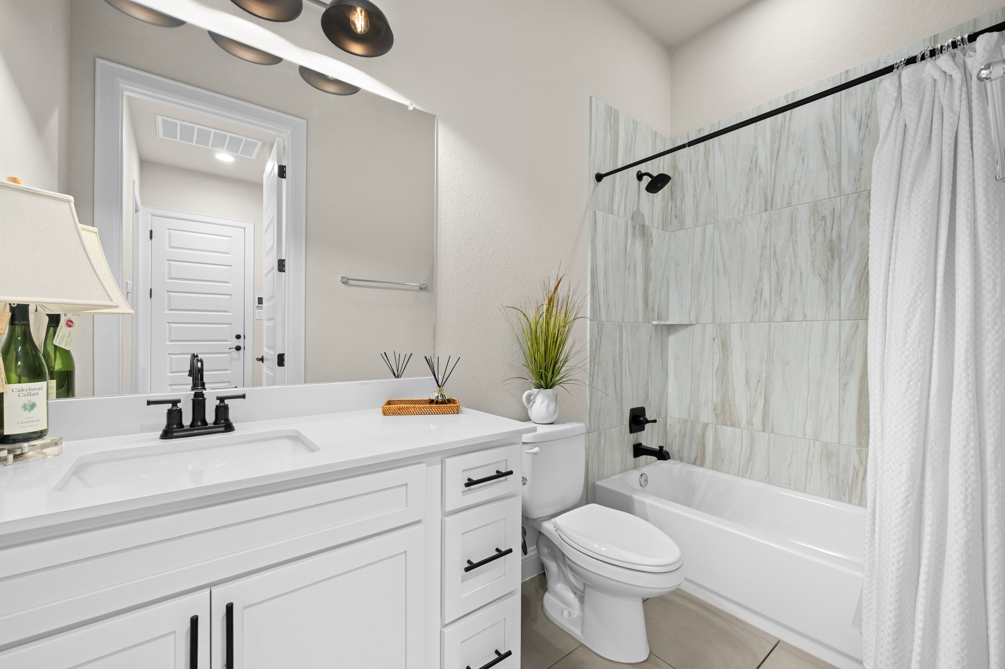 2100 Highland Ridge Road Georgetown, TX 78628 - Photo 23 of 30 A well-appointed bathroom features a pristine white vanity, modern fixtures, and elegantly tiled shower.