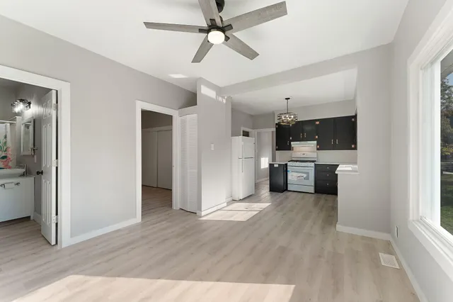 a view of a kitchen with a sink a refrigerator and a window