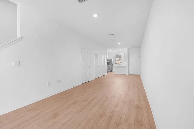 a view of empty room with wooden floor