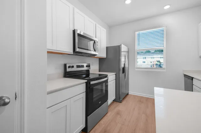 a kitchen with stainless steel appliances a refrigerator a stove a microwave and cabinets