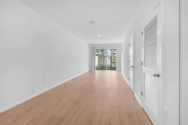 a view of a room with wooden floor and window