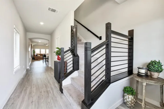 a view of a hallway view with wooden floor and a potted plant