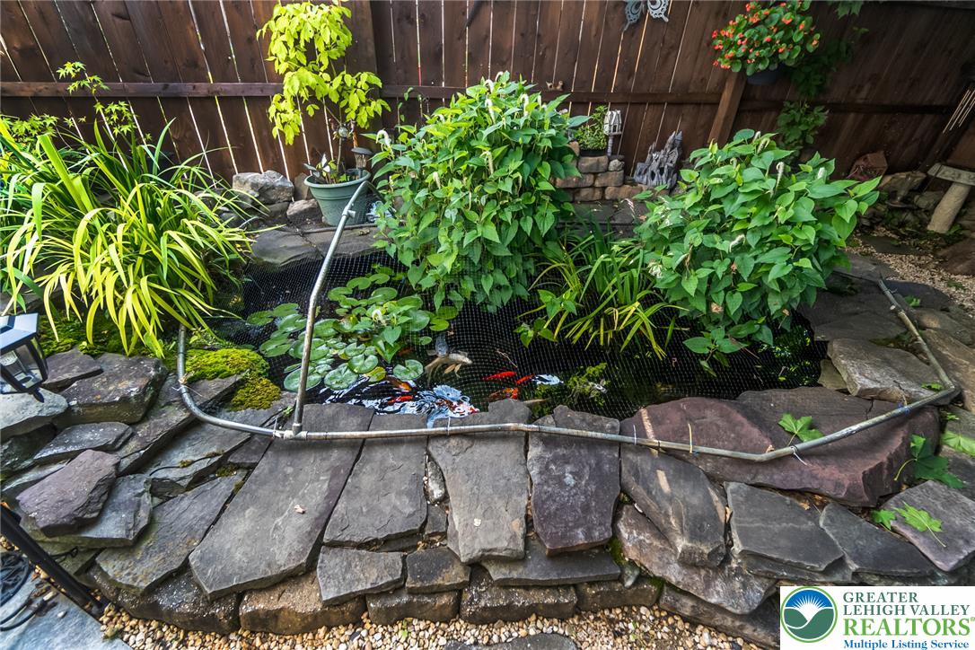 365 Rock Street Easton, PA 18042 - Photo 44 of 50 An inviting water feature with lush greenery creates a serene outdoor retreat.