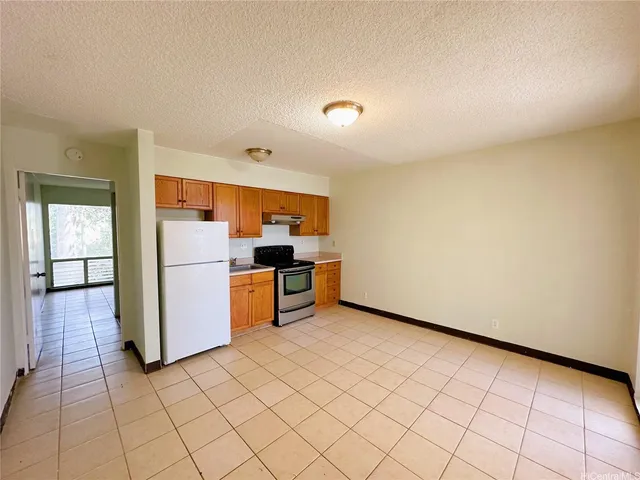 a view of kitchen with refrigerator and cabinets