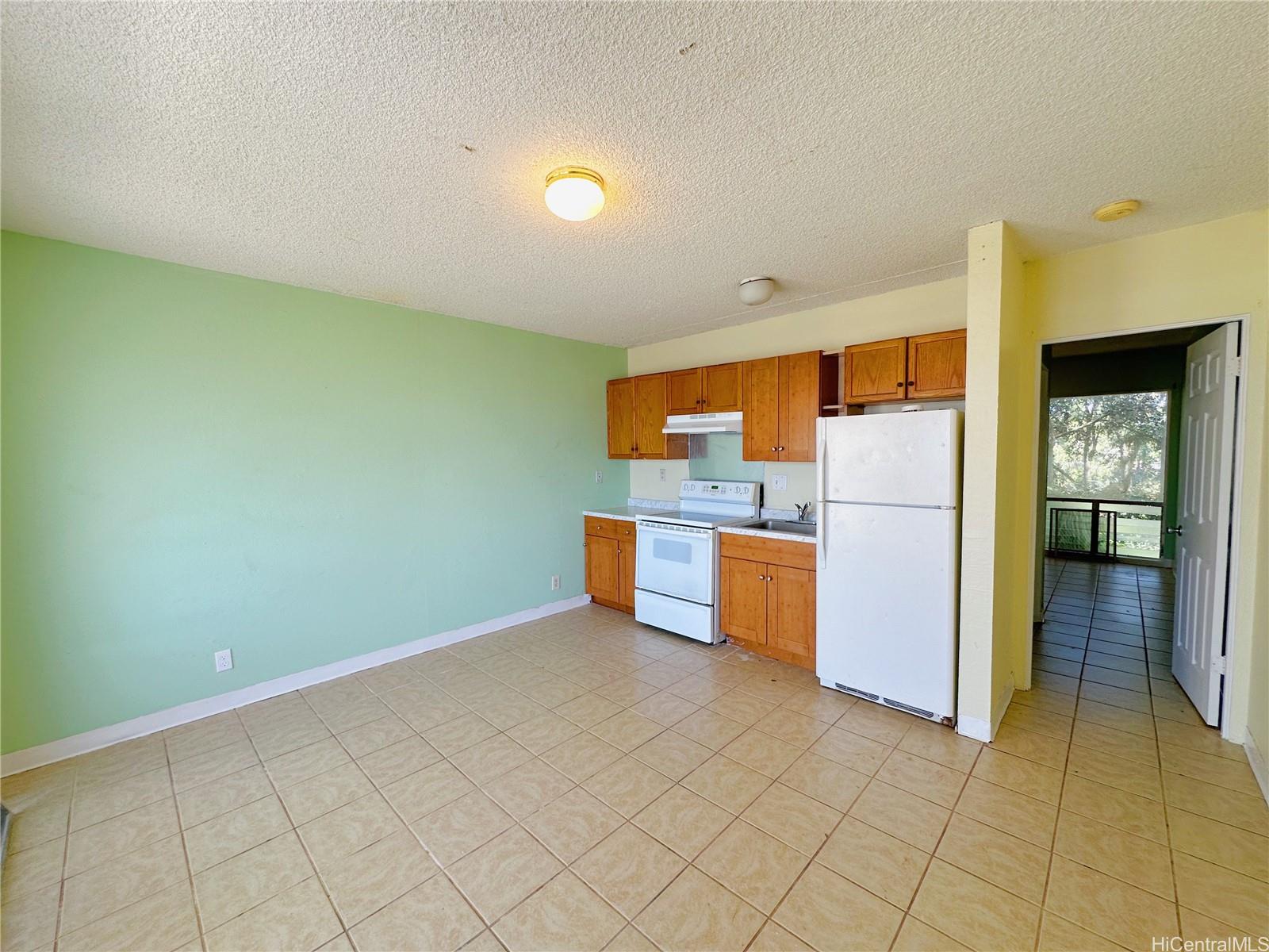 142 Lakeview Circle Wahiawa, HI 96786 - Photo 7 of 10 a kitchen with refrigerator and window