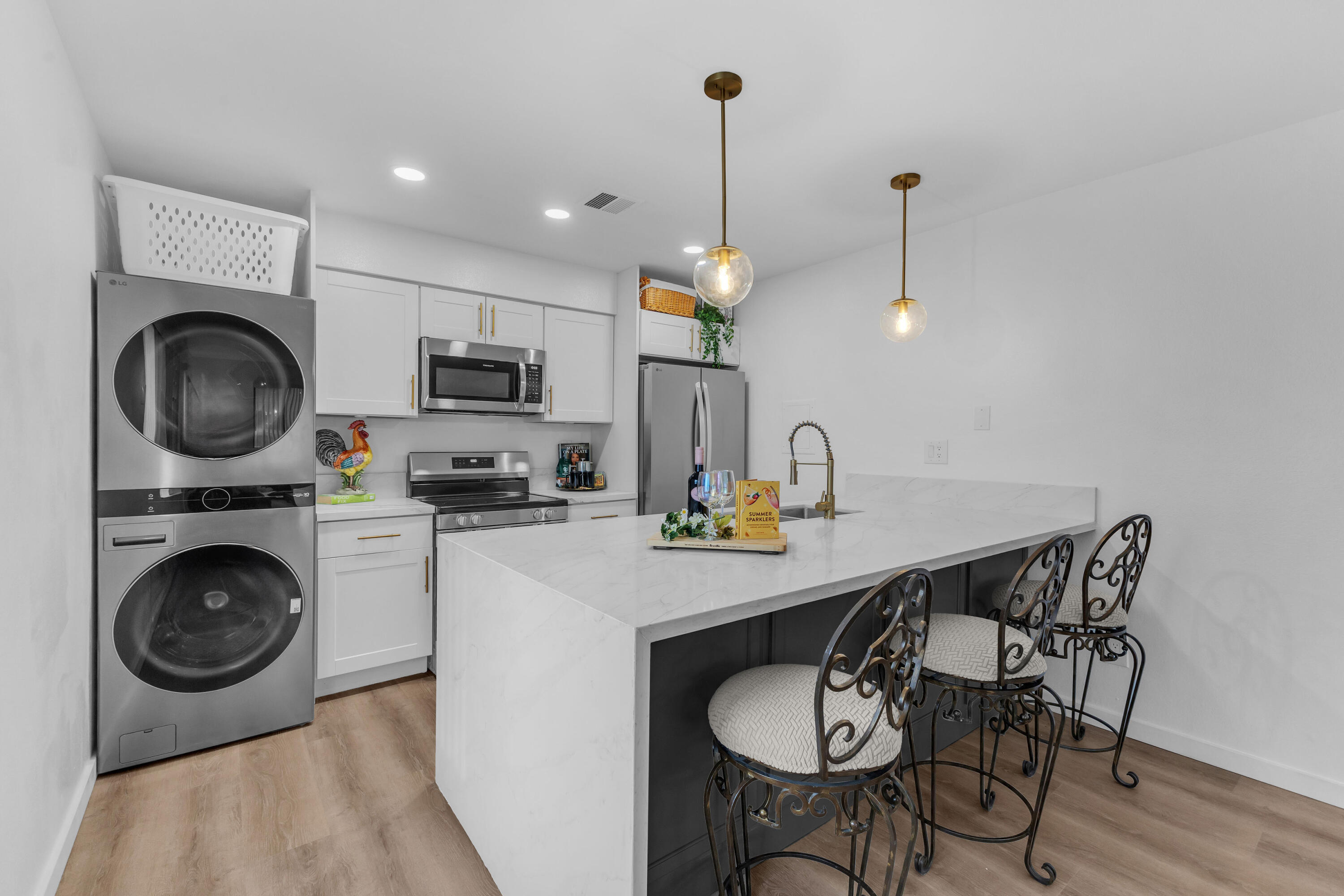 72682 Thrush Road, Unit 1 Palm Desert, CA 92260 - Photo 1 of 40 a kitchen with stainless steel appliances a white table chairs and a wooden floor