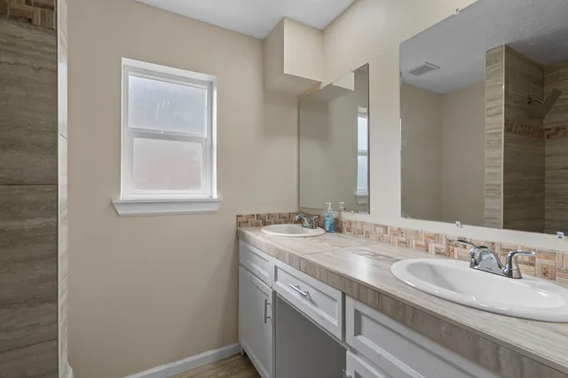 a bathroom with 2 sink and a mirror