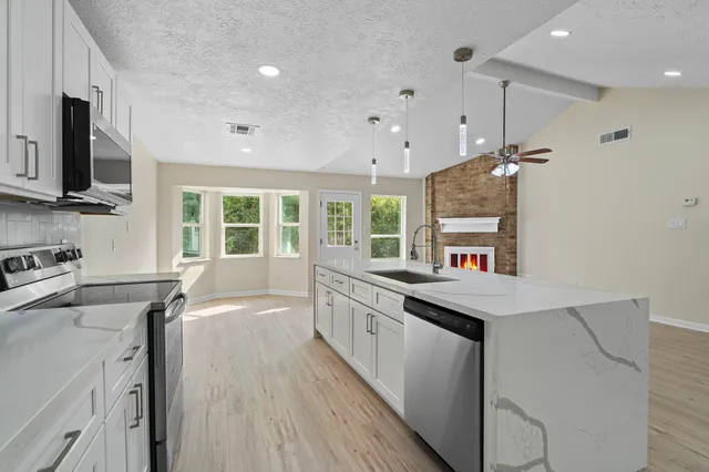 a kitchen with stainless steel appliances granite countertop a sink stove and refrigerator