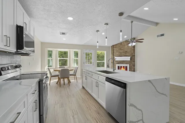 a kitchen with granite countertop a sink appliances counter top space and furniture