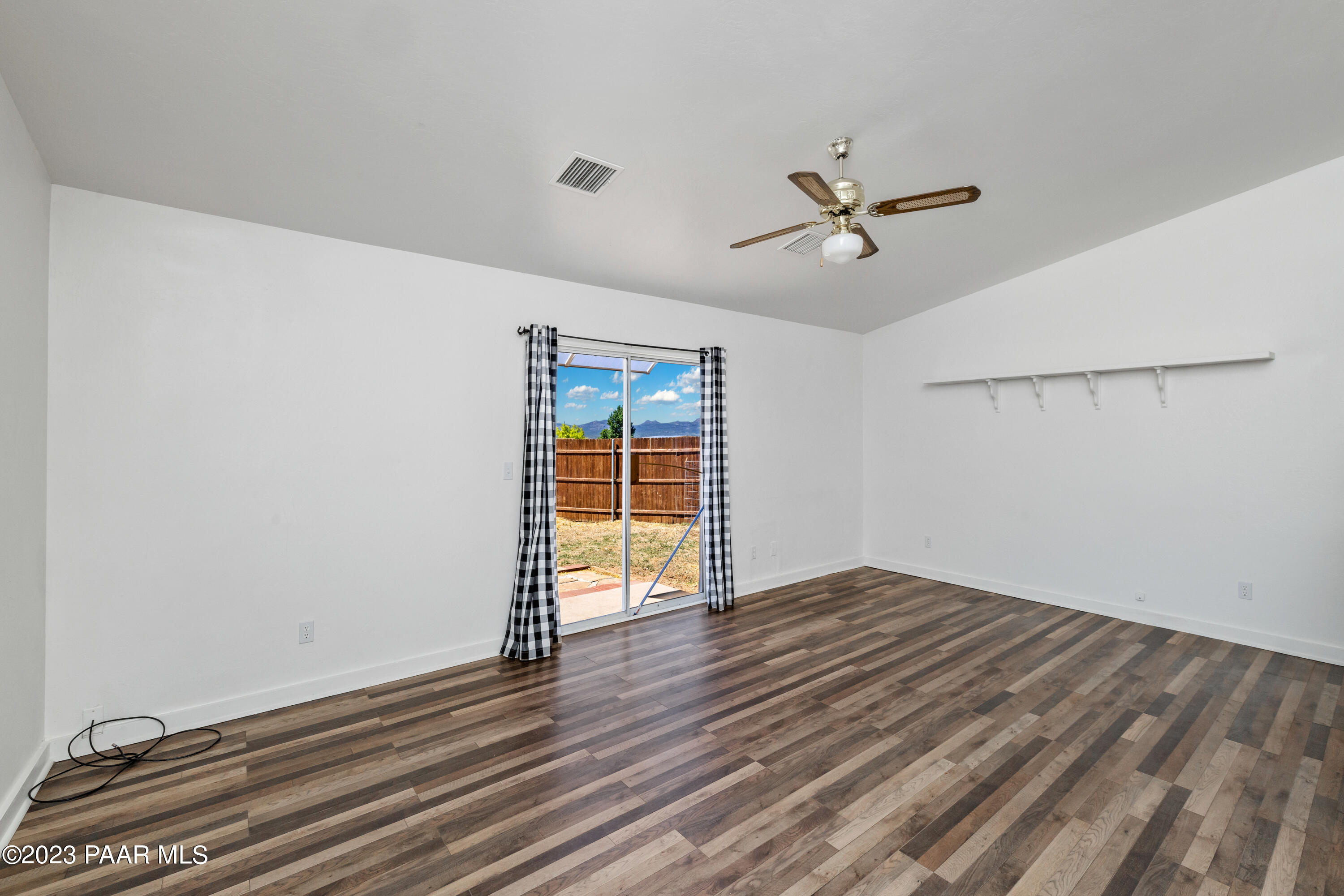 815 West Ahonen Road, Unit 4 Paulden, AZ 86334 - Photo 6 of 27 an empty room with wooden floor ceiling fan and windows
