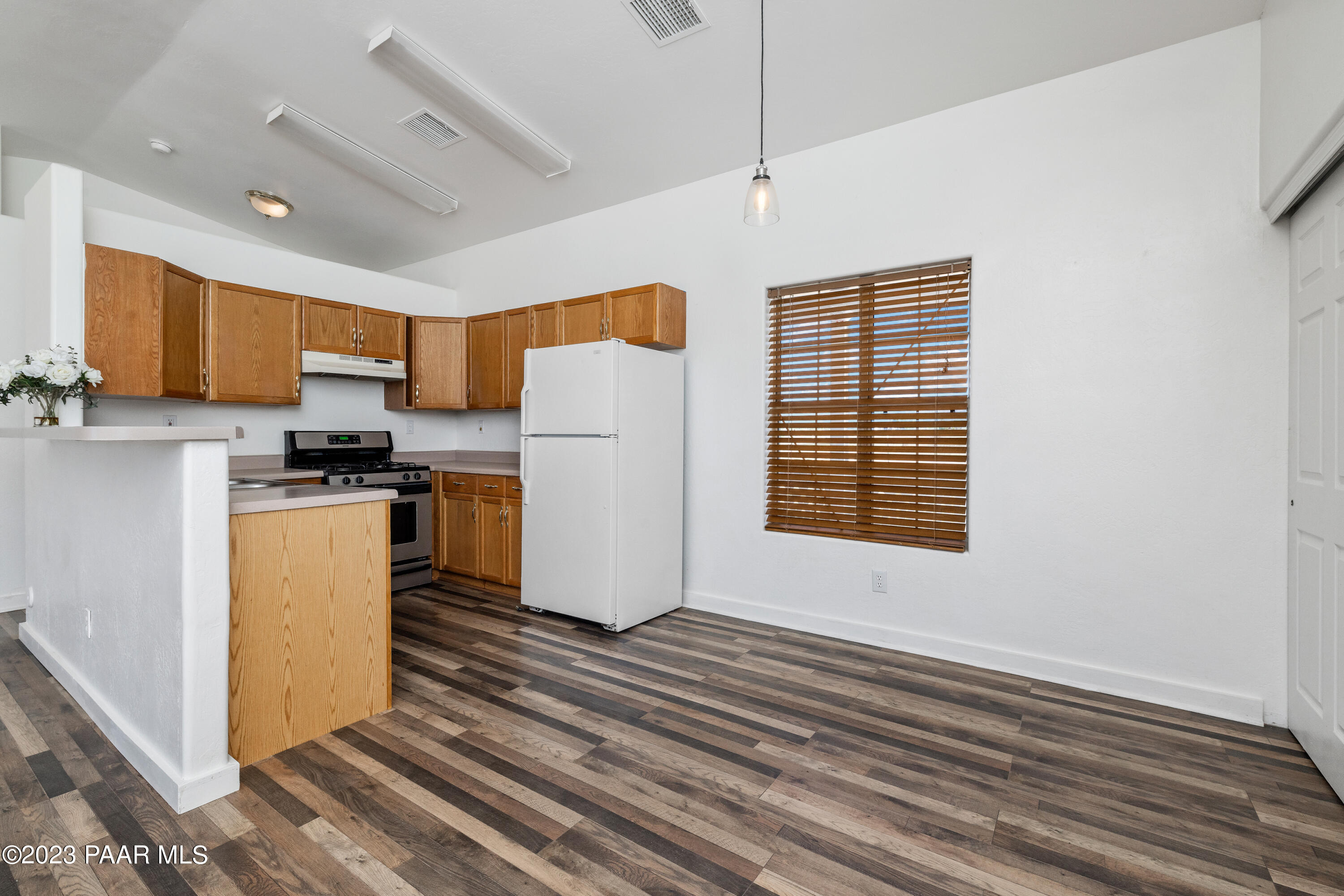 815 West Ahonen Road, Unit 4 Paulden, AZ 86334 - Photo 8 of 27 a kitchen with a refrigerator a stove top oven a sink and dishwasher with wooden floor