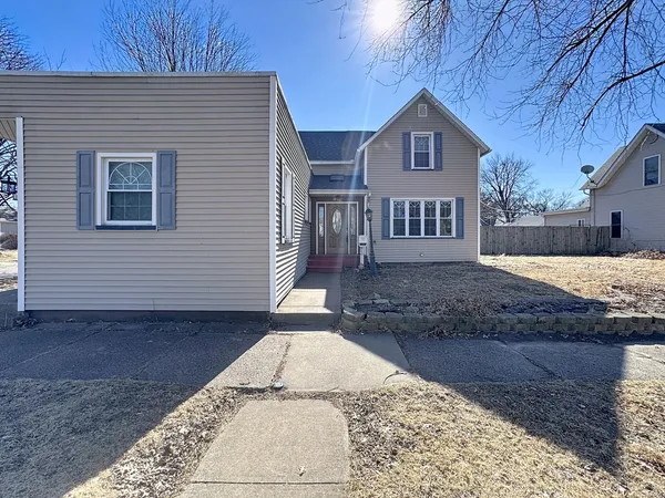 a view of a grey house with a yard