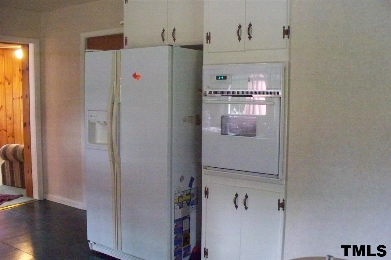 1303 Fairground Road Dunn, NC 28334 - Photo 3 of 23 a white refrigerator freezer and a wooden floor