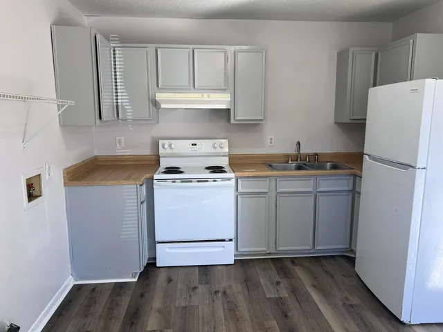 a kitchen with a refrigerator sink and cabinets