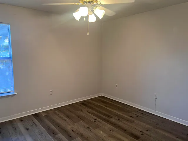 a view of wooden floor and chandelier fan in a room