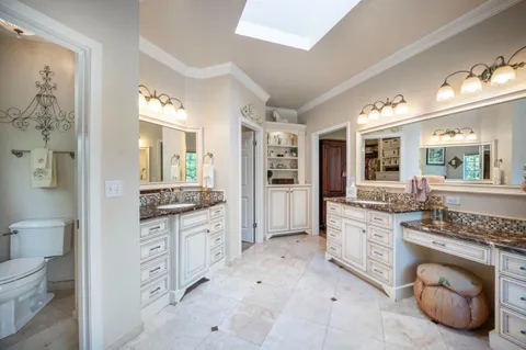a kitchen with kitchen island granite countertop a sink cabinets and stainless steel appliances