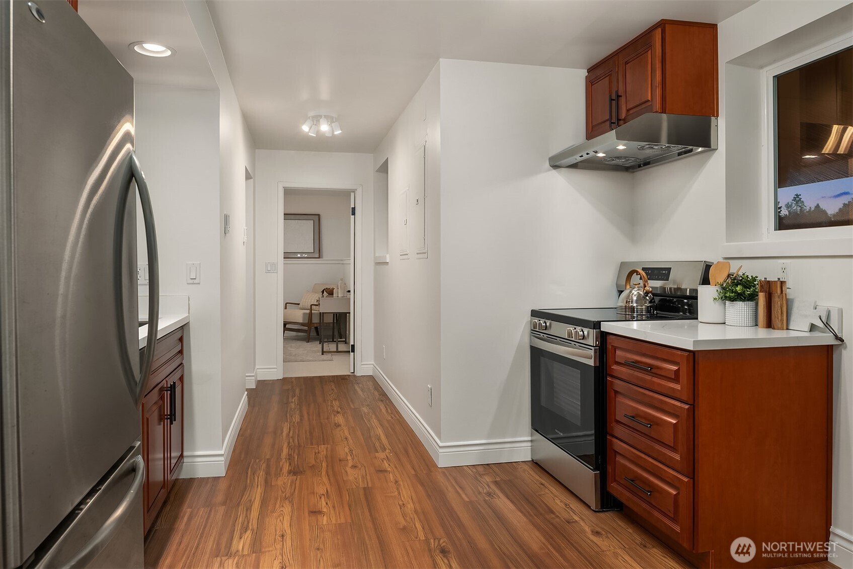 13621 18th Avenue Southwest Burien, WA 98166 - Photo 28 of 40 a kitchen with stainless steel appliances granite countertop a refrigerator a stove and a wooden floors