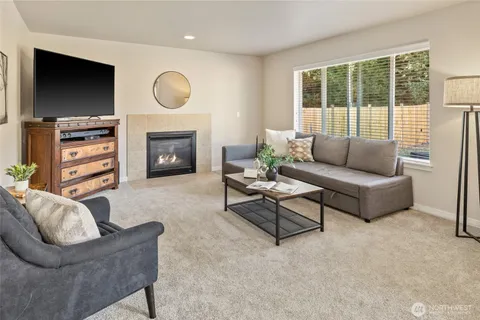 a living room with furniture a fireplace and a flat screen tv