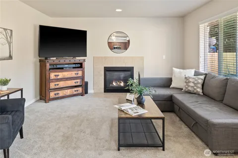 a living room with furniture a flat screen tv and a fireplace