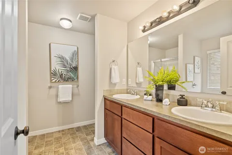 a bathroom with a double vanity sink and a mirror