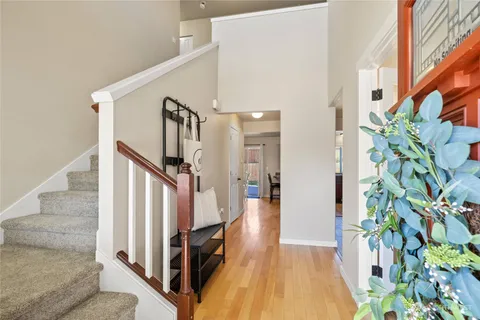 a view of a hallway with wooden floor and stairs