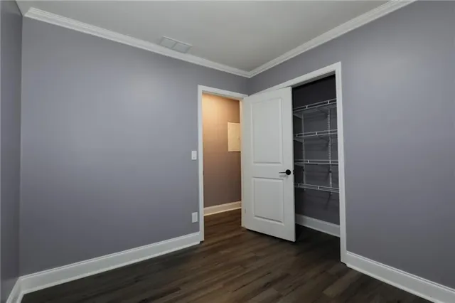 an empty room with wooden floor and closet