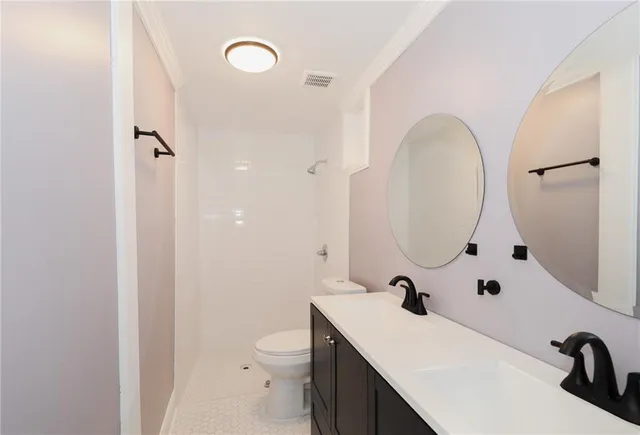 a bathroom with a sink a toilet and a mirror