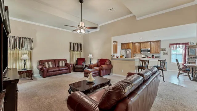a living room with furniture kitchen view and a chandelier