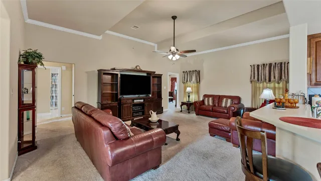 a living room with furniture a flat screen tv and a window