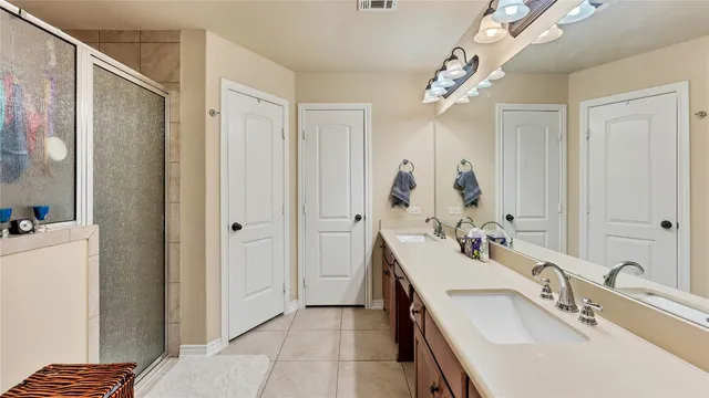 a bathroom with a double vanity sink mirror and shower
