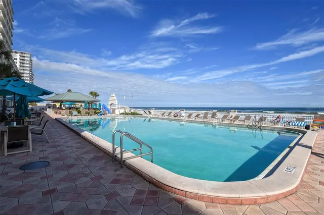 a patio with a table and chairs under an umbrella