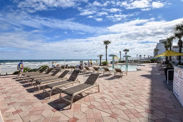 a patio with a table and chairs under an umbrella