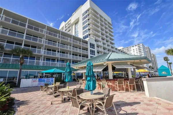 a view of a swimming pool with a table and chairs under an umbrella