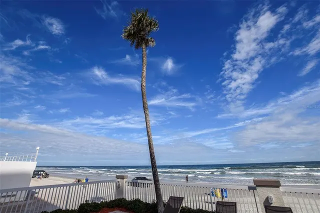 a view of a patio with table and chairs under an umbrella with a fire pit