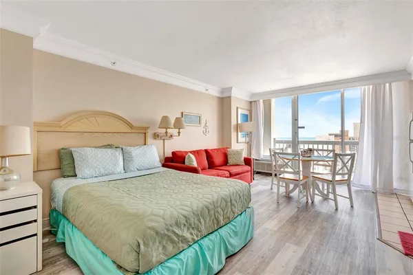 a living room with a bed furniture and a wooden floor