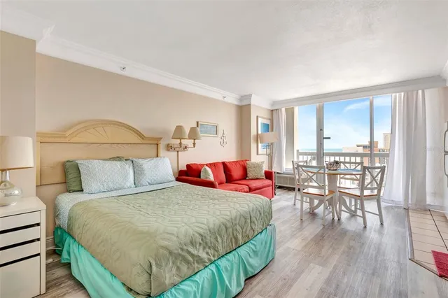 a living room with a bed furniture and a wooden floor