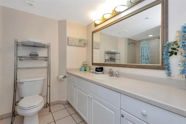 a spacious bathroom with a granite countertop sink toilet and a mirror