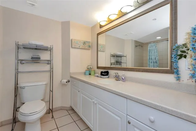 a spacious bathroom with a granite countertop sink toilet and a mirror