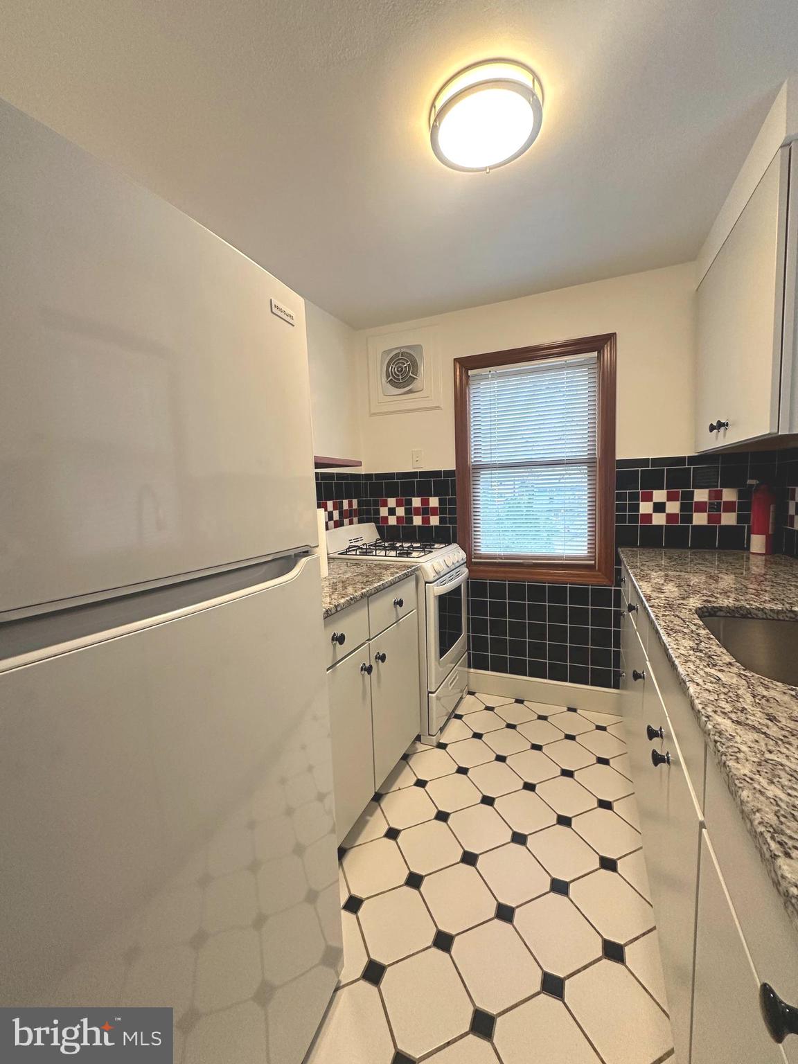1009 Parkside Avenue, Unit 2 Ewing, NJ 08618 - Photo 16 of 23 a kitchen with granite countertop a stove a sink and a refrigerator