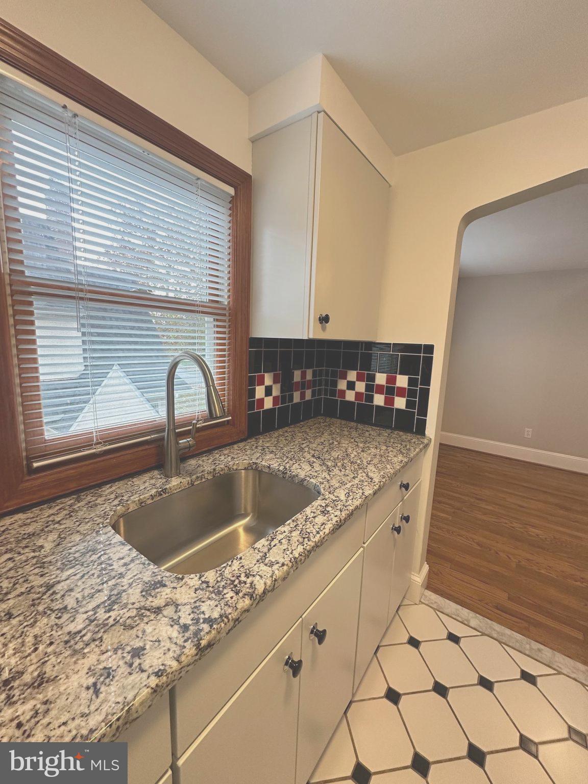 1009 Parkside Avenue, Unit 2 Ewing, NJ 08618 - Photo 19 of 23 a kitchen with granite countertop a sink a stove and a window