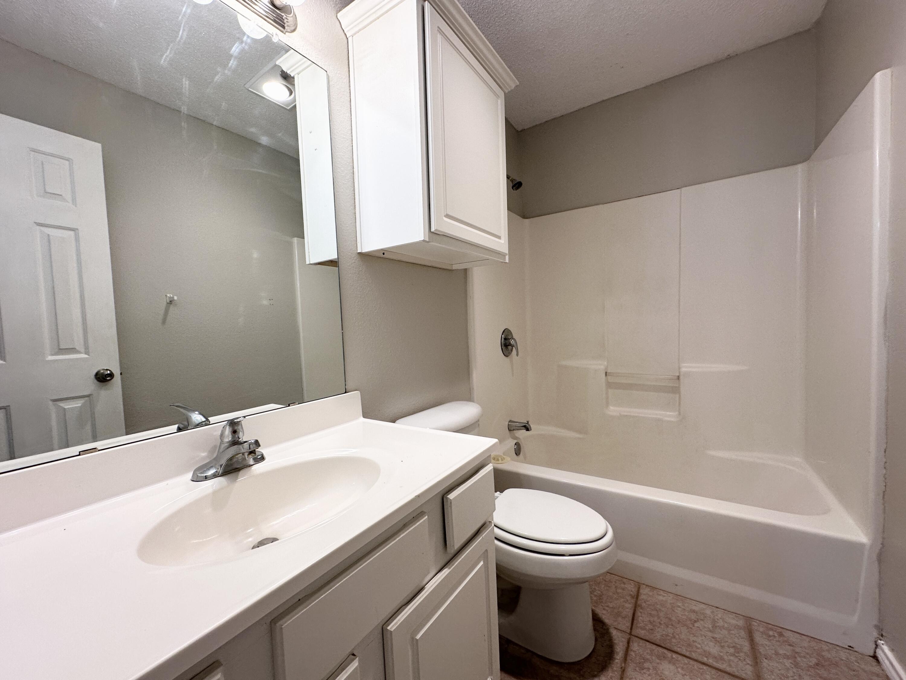 615 North Elkhart Avenue Lubbock, TX 79416 - Photo 12 of 15 a bathroom with a sink a toilet and a mirror